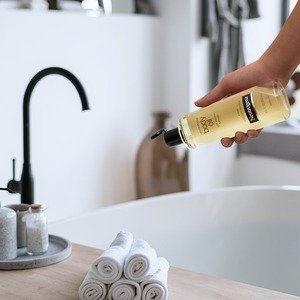 Neutrogena Moisturizing Sesame Body Oil for dry skin being poured into bath tub